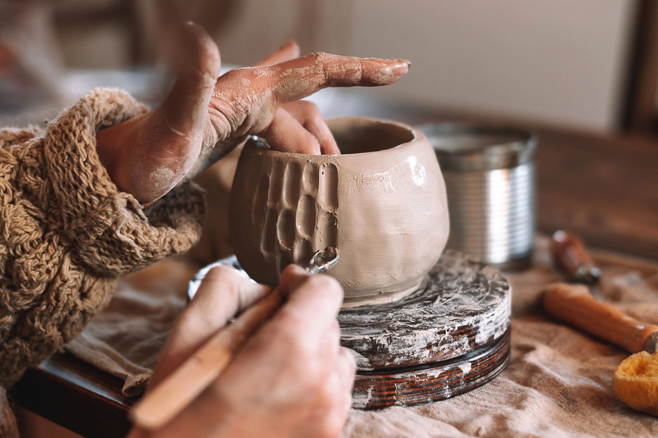 Ceramic artist forming a clay mug by hand