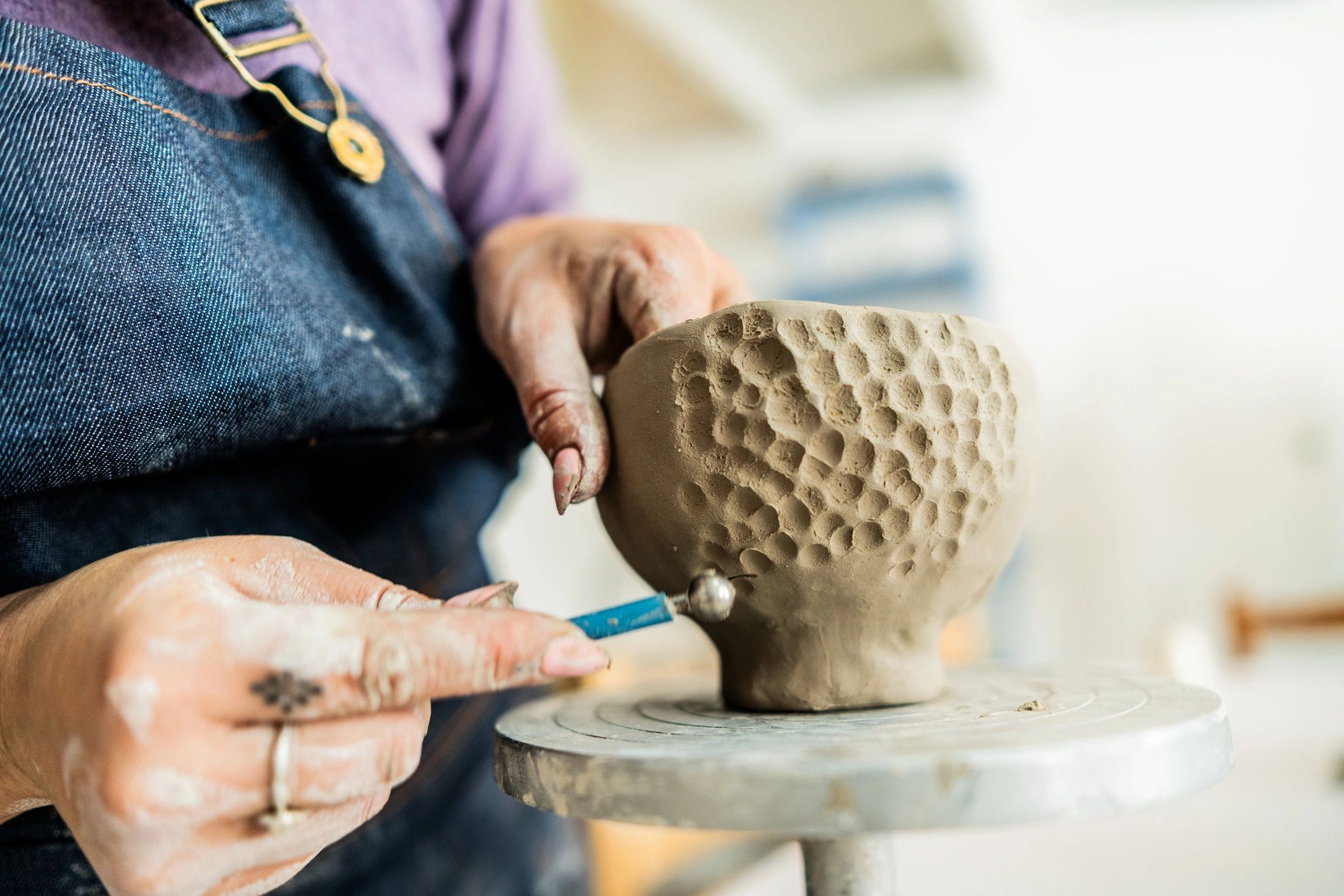 Close-up of hands shaping clay in a ceramics workshop